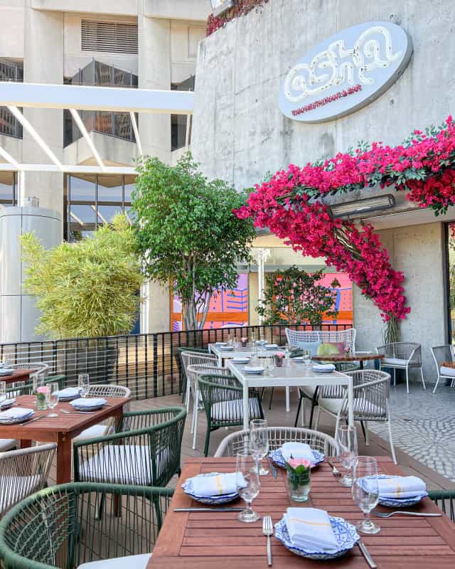 Outdoor dining at Osha Lounge, featuring lush greenery and elegant setting for events.