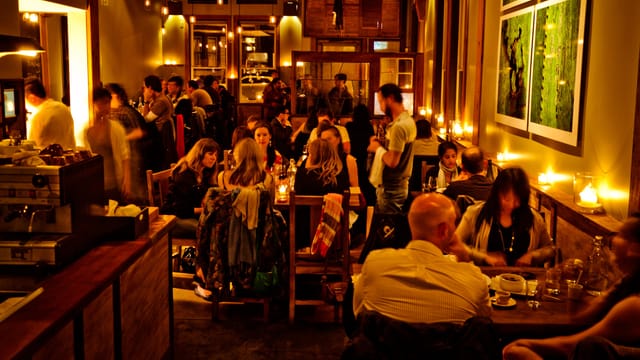 Vibrant Flour + Water restaurant with warm candlelight, ideal for gatherings and events.