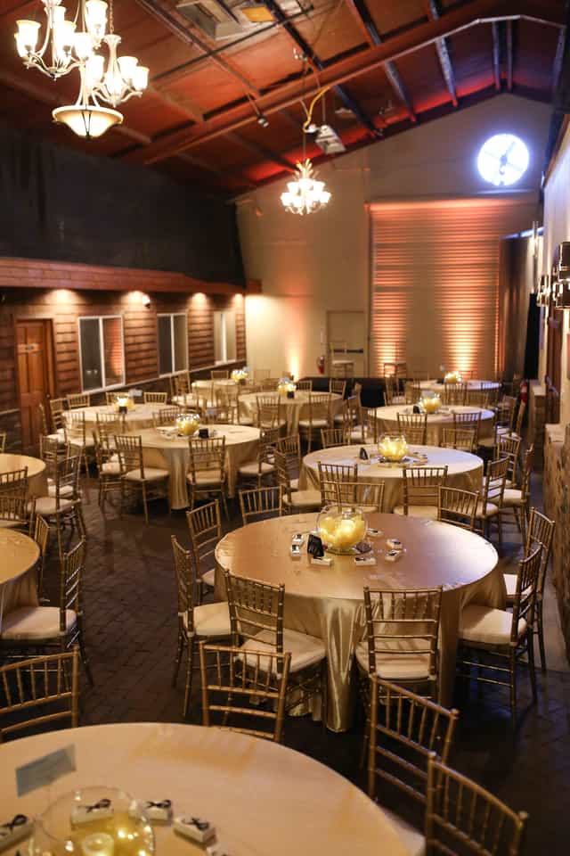 Elegant event space at Redwood City Station with golden tablecloths for gatherings.