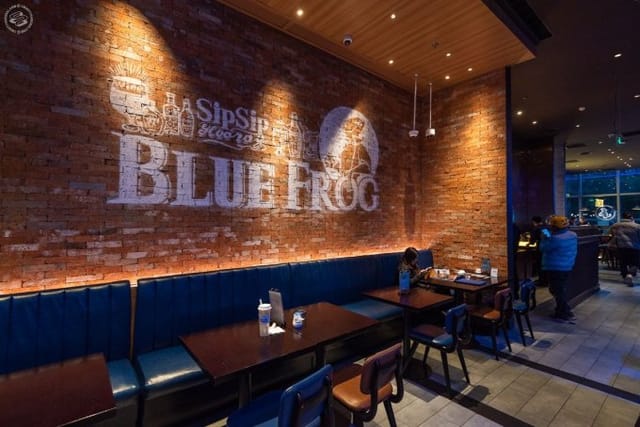 Modern restaurant with warm brick wall, ideal for networking and social events.