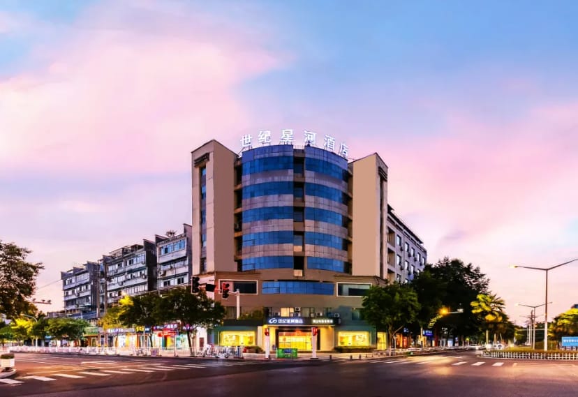 Modern Shiji Huangshan Hotel Beijing with sleek glass facade at sunset, perfect for events.