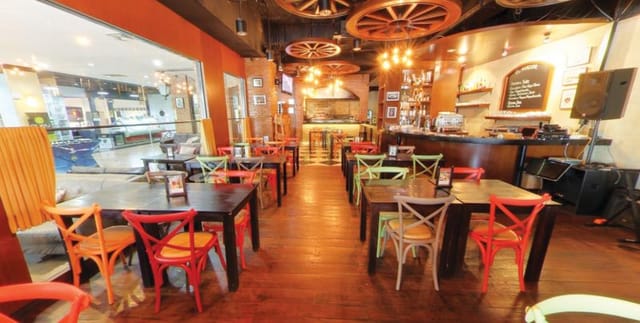 Vibrant rustic restaurant venue with colorful chairs for casual gatherings and networking.