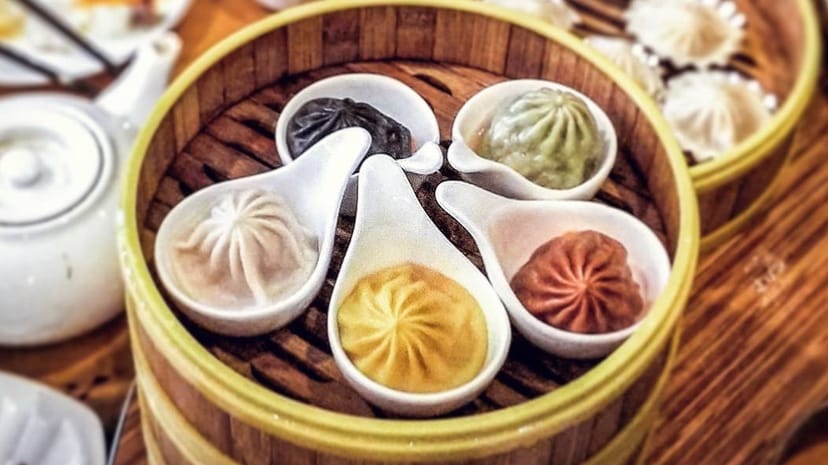 Assorted dumplings in a steamer basket at Koi Palace for culinary events.