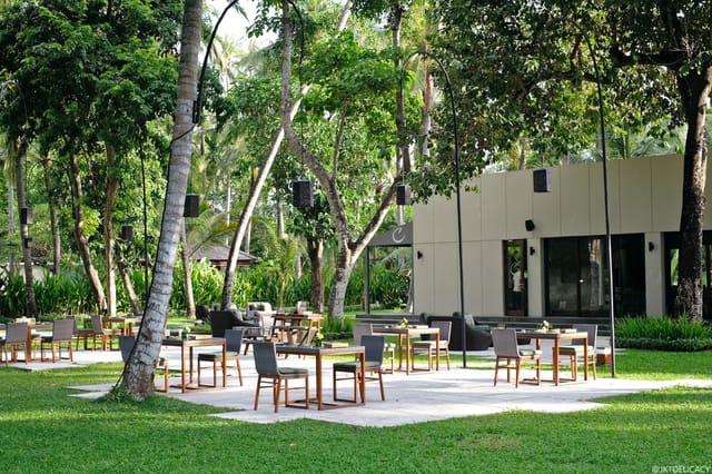 Outdoor meeting space at Cuca Restaurant, lush greenery, ideal for corporate retreats.