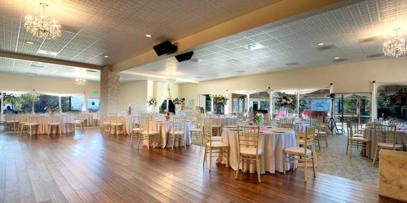 Elegant Crystal Ball Room for weddings and corporate events with round tables and floral centerpieces.