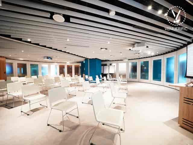 Modern meeting room with white chairs, ideal for conferences and workshops.