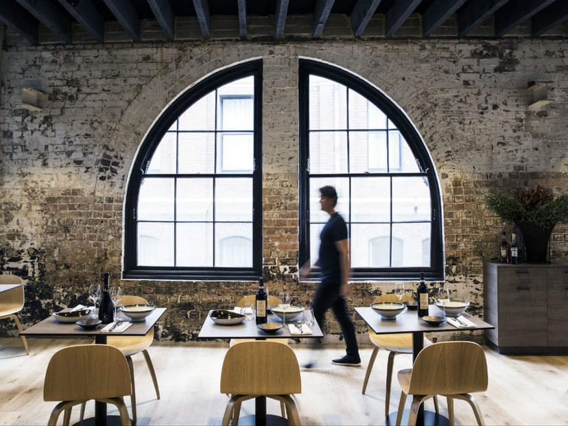 Modern restaurant venue with arched windows, ideal for dining and networking events.