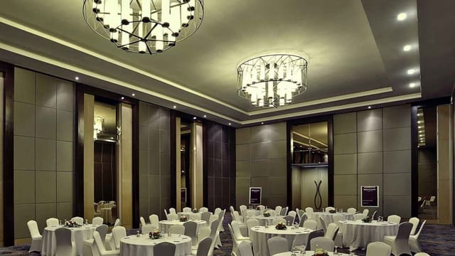 Elegant conference room with round tables, ideal for corporate events and weddings.
