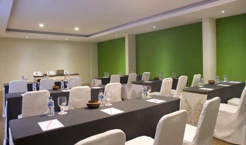 Hotel Santika Kuta meeting room with black and white tables, ideal for corporate events.