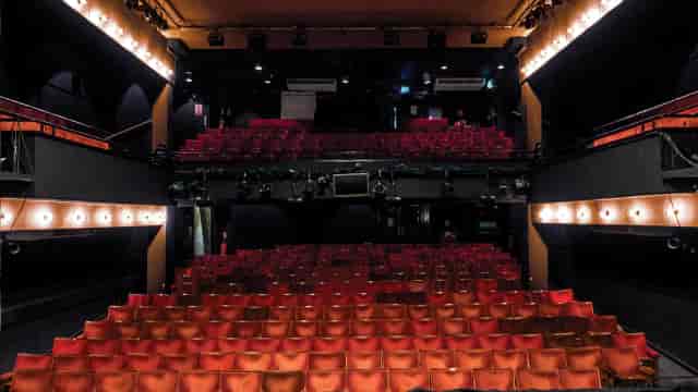 Performing arts theater with tiered seating and professional lighting for events.