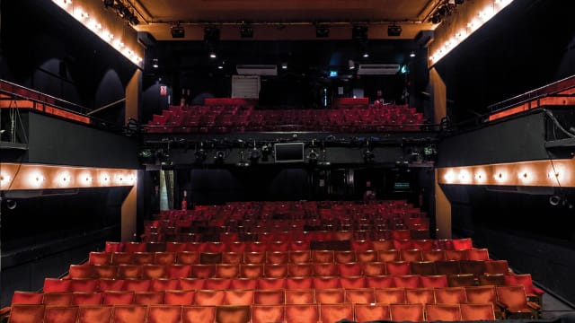 Performing arts theater with tiered seating and professional lighting for events.