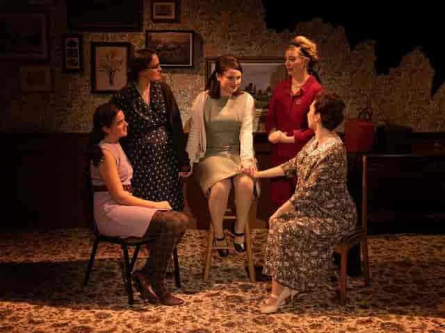 Women in lively discussion at OSO Arts Centre's inviting performing arts theater.
