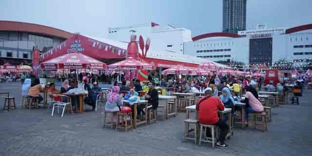 Lively Jakarta International Expo Hall B with vibrant umbrellas at a food festival.