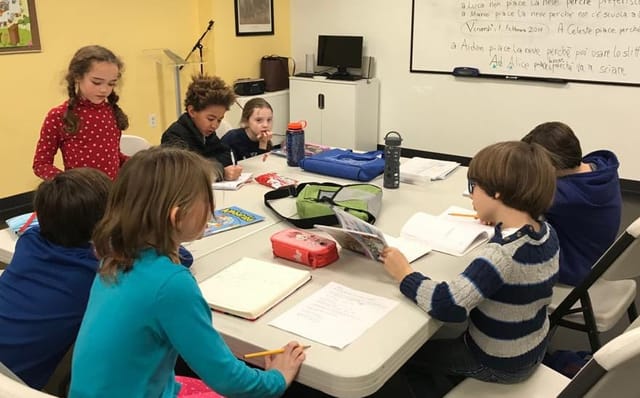 Children engaged in collaborative learning at Italian Cultural Society classroom.
