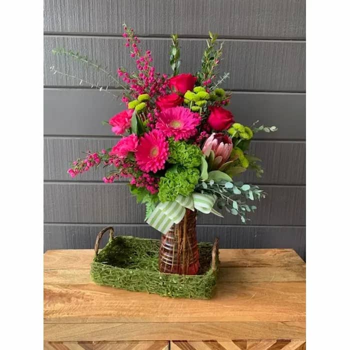 Vibrant floral centerpiece with gerberas and roses for event decor at The Pink Door.
