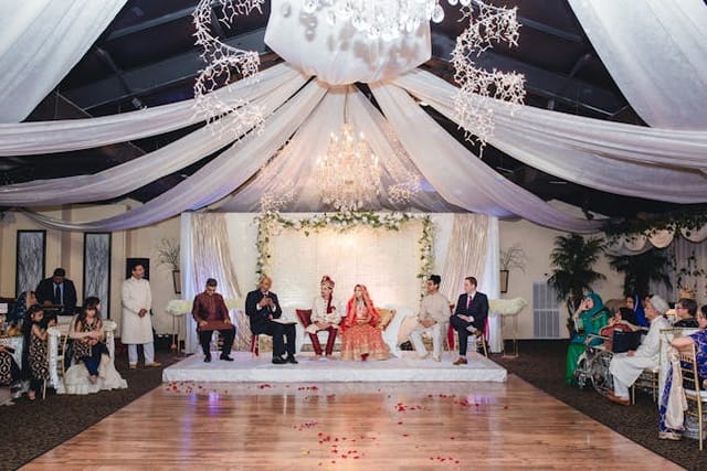 Elegant Quinceanera venue with floral arrangements and stage at Mona Lisa Events.