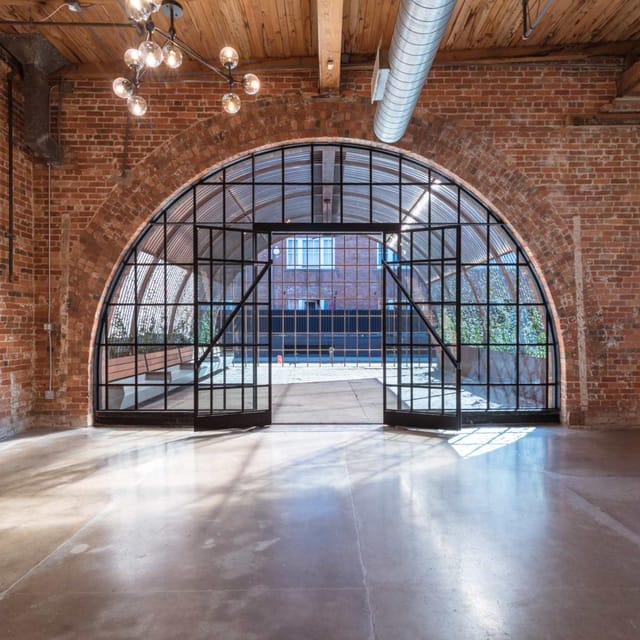 Modern warehouse venue with arched entryway, ideal for corporate and social events.
