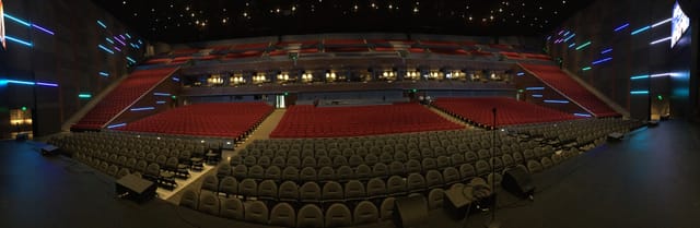 Modern auditorium with red and grey seats, ideal for conferences and performances.