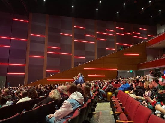 Packed auditorium with red lighting at Smart Financial Centre for lively events.