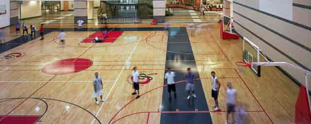 Campus Recreation and Wellness Center gym with polished wooden floor for sports events.