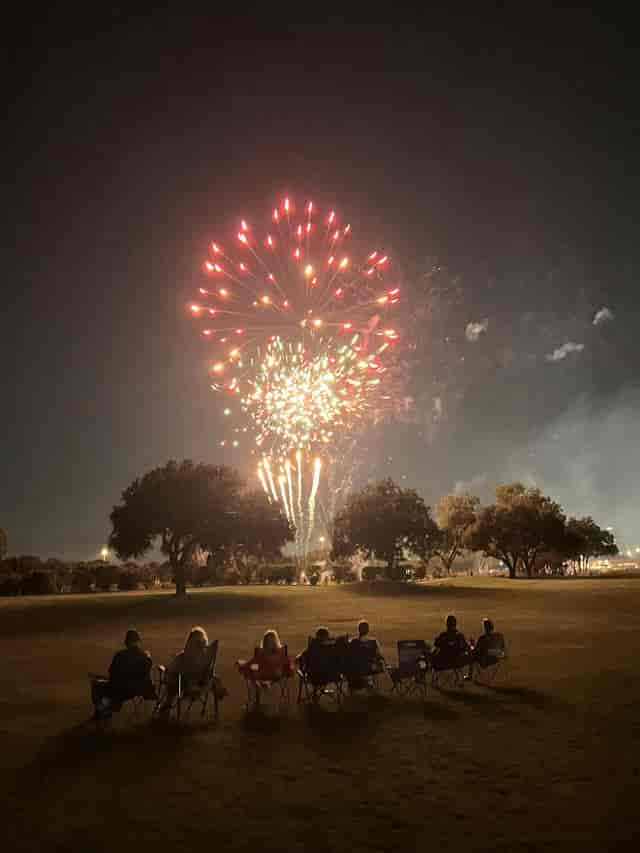 Vibrant fireworks above trees in Sugar Creek Country Club's Garden Room for celebrations.