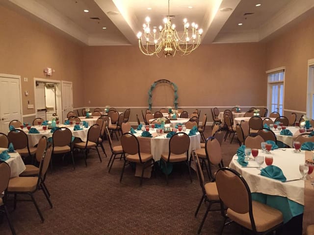 Elegant banquet room in The Club at Pecan Grove with circular tables for events.