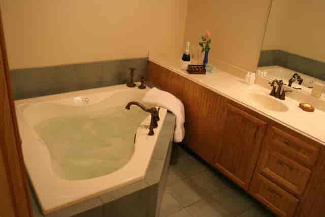 Luxurious bathroom with jacuzzi tub in The Maple Room, ideal for upscale retreats and events.