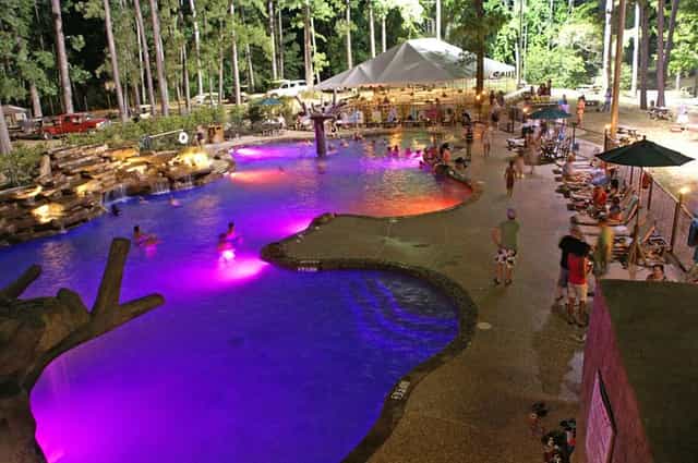 Vibrant outdoor restaurant venue with illuminated pool for evening events and gatherings.