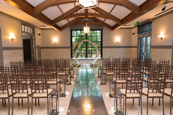 Elegant wedding ceremony setup at The ARK with floral archway and natural lighting.