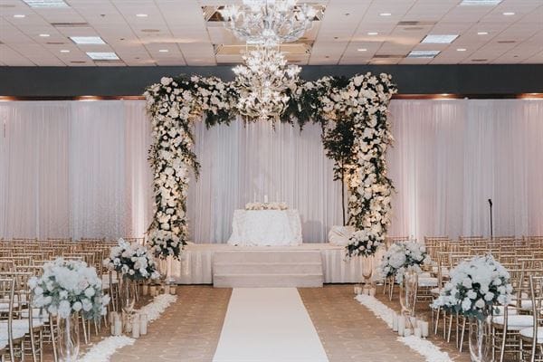 Elegant wedding ceremony setup with floral altar and gold chiavari chairs at HORIZONS Conference Center.