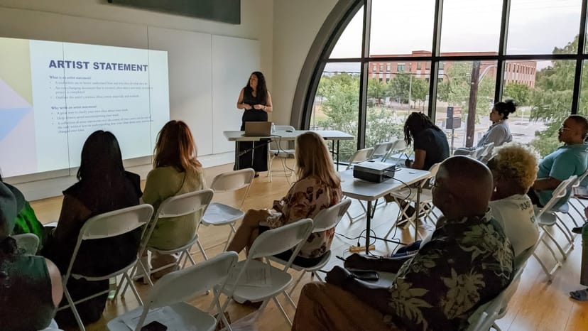 Intimate workshop space with white chairs and projector screen in Houston Arts Alliance.