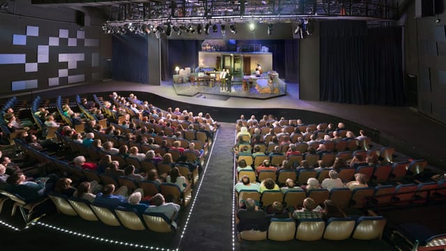 "Performance space at Wortham Center with engaged audience and stage for events and presentations"