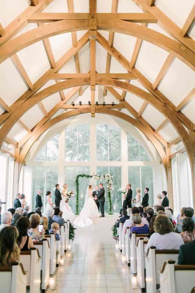 Elegant wedding ceremony at The Chapel in The Gardens, featuring natural light and floral decor.