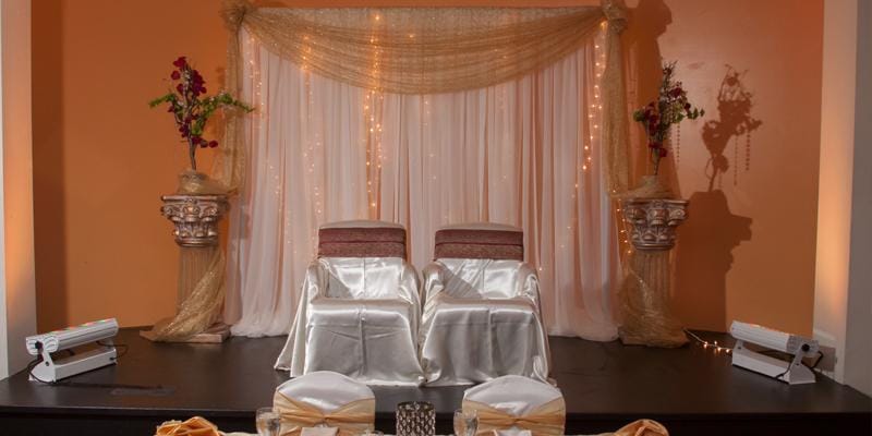 Function Room stage with elegant drapery for weddings and formal events in India House.