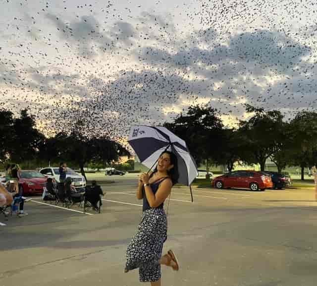 "Participant with umbrella at Houston Audubon community outreach event, enjoying nature."