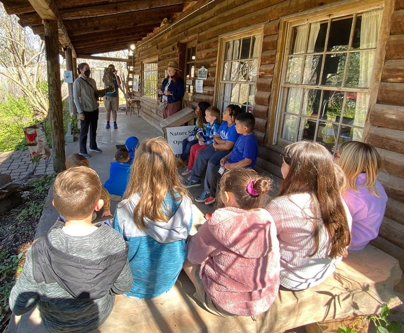 Log cabin in Houston Audubon with group, perfect for family-friendly workshops and events.