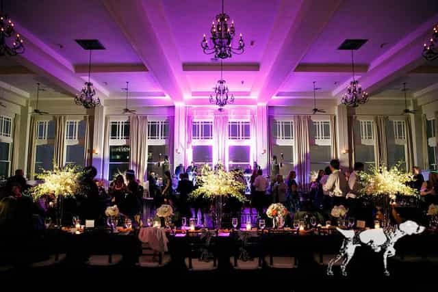Elegant Main Ballroom with purple lighting, floral centerpieces for upscale events.