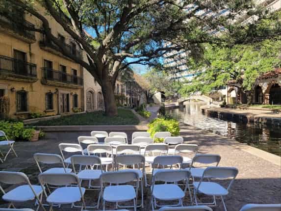 Ceremony Terrace at Venetian Terrace with white chairs by a serene canal, perfect for weddings.