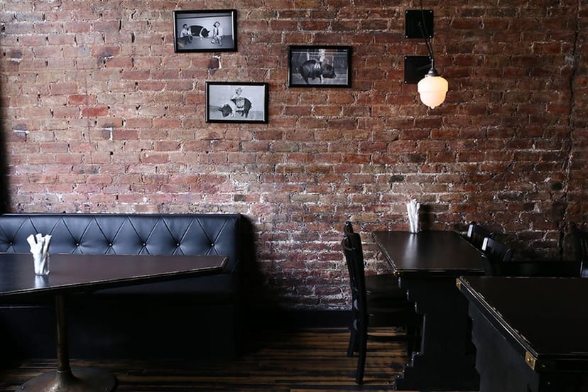 Stylish dining area with exposed brick, ideal for casual meetings and workshops.