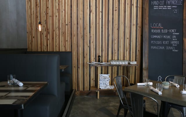 Dining area at Blind Butcher with rustic wooden wall, ideal for intimate events and meetings.