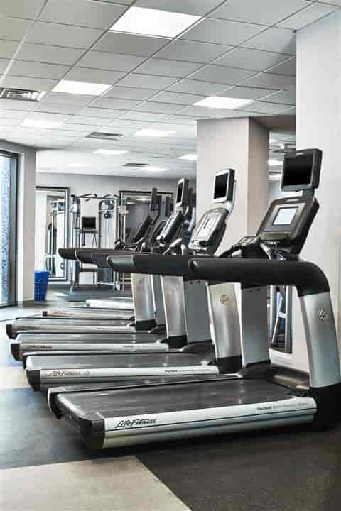 Modern gym in Renaissance Dallas Hotel with high-tech treadmills for corporate wellness events.