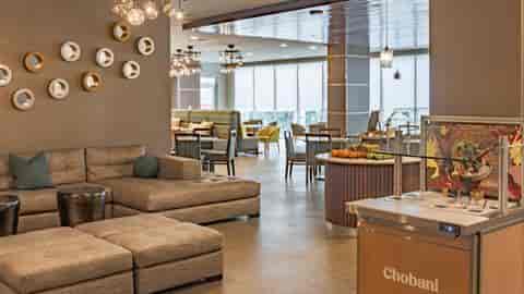 Modern kitchenette and sectional couch in Element Dallas Downtown East for networking events.
