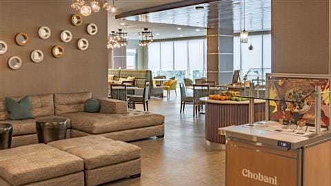 Modern kitchenette and sectional couch in Element Dallas Downtown East for networking events.