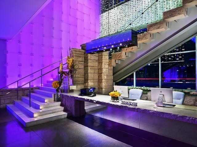 Modern reception area with marble desk and purple lighting at W Dallas Studio 2.