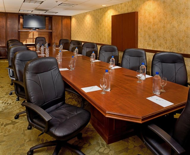 Conference room in Embassy Suites Dallas, featuring a long wooden table for meetings.
