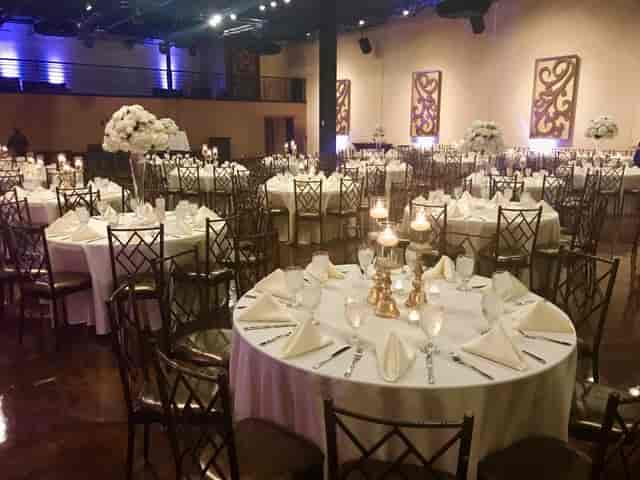 Elegant ballroom with white tablecloths, ideal for weddings and corporate events.