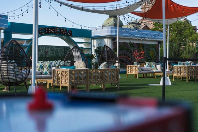 Vibrant outdoor event space with wicker seating and string lights at Worthington Hotel.