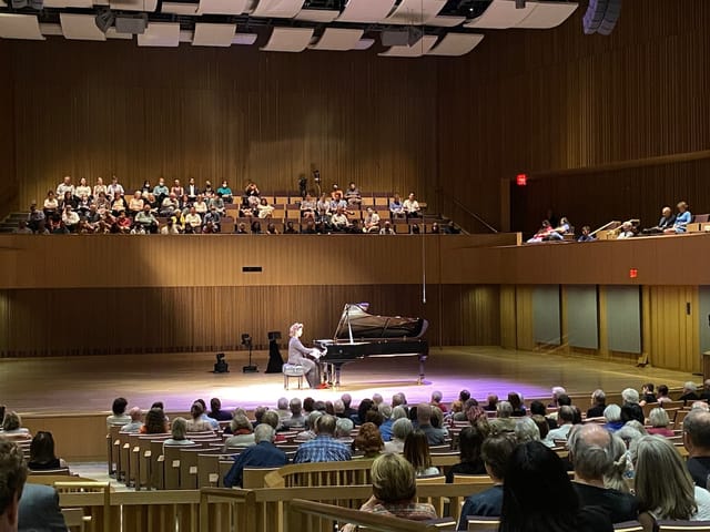 Van Cliburn Concert Hall concert with engaging pianist and warm wood paneling ambiance.