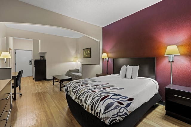 Meeting room in Red Roof hotel with a cozy bed, ideal for business events and gatherings.