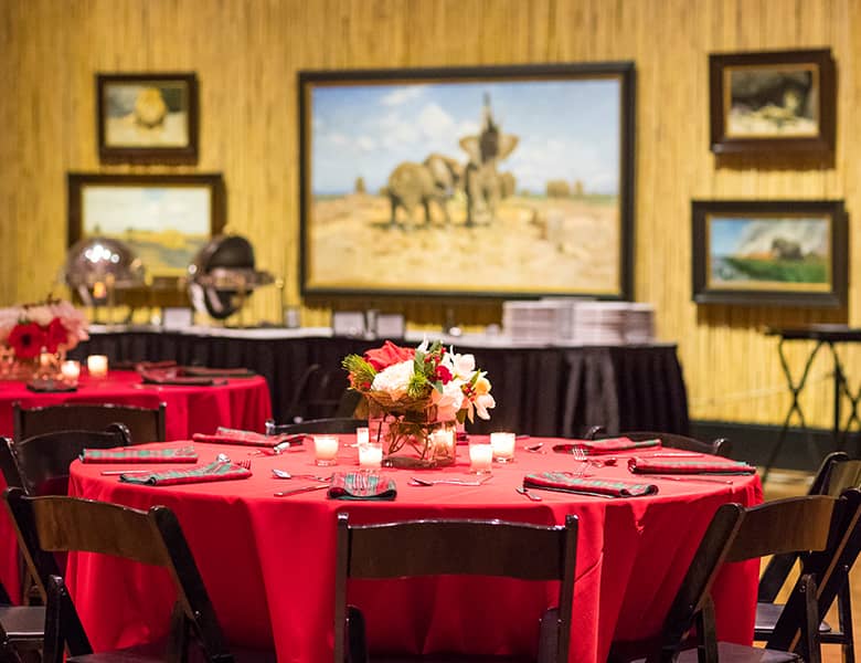 Portraits of the Wild Art Gallery, elegant red-draped tables for sophisticated events.